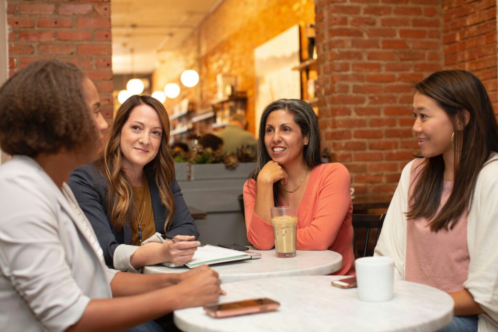 Des femmes âgées assises sur une table en train de boire un café 