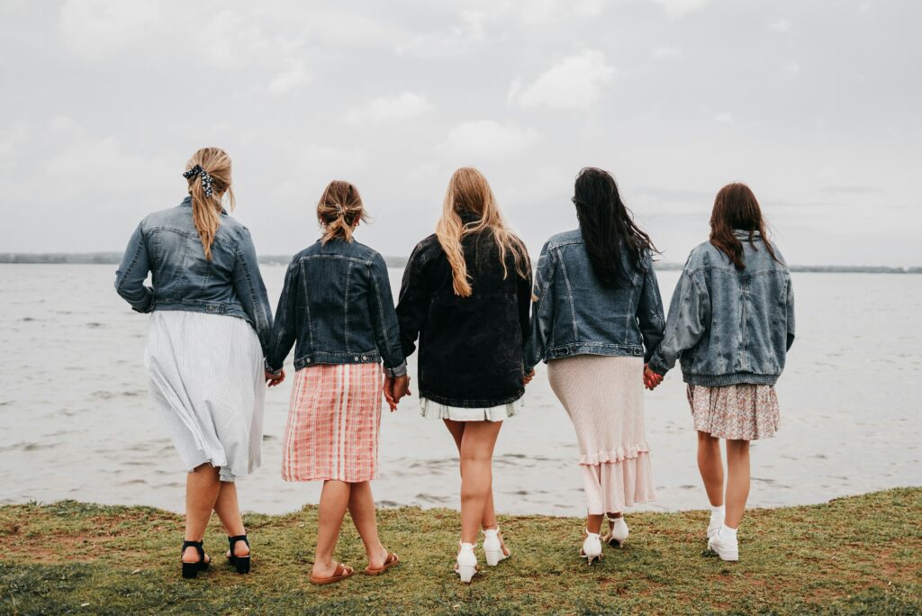 5 femme vues de dos en train de se tenir la main